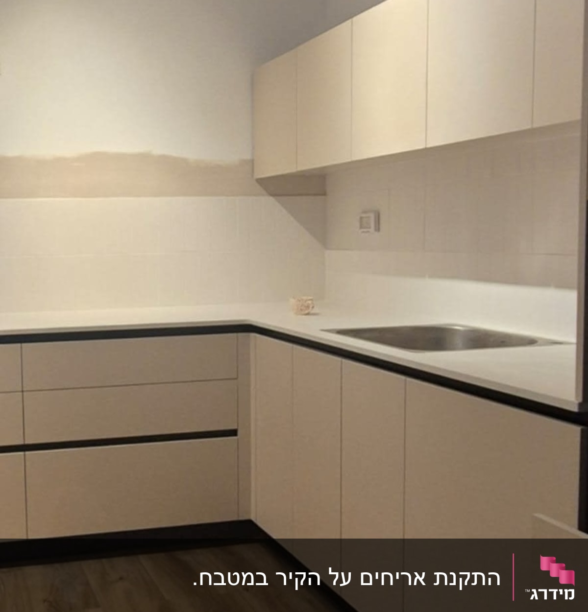מטבח חדש עם ארונות לבנים ומשטח עבודה